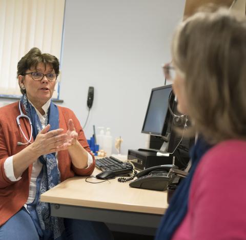 A GP using hand gestures whilst talking to a woman with ovarian cancer