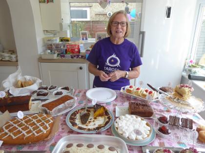 Pauline, a Target Ovarian Cancer fundraiser, standing behind a table of homemade cakes
